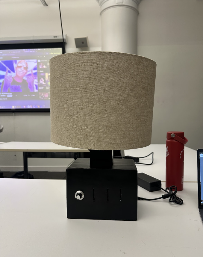 The finished lamp: a black cardboard cube base with a dial and three slider slots, under a beige linen drum shade