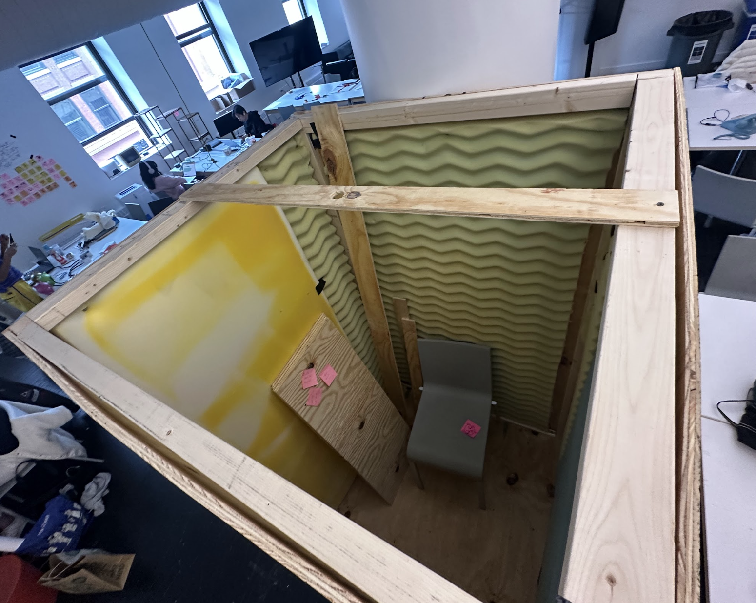 Looking down into the booth at the foam-lined walls and a chair